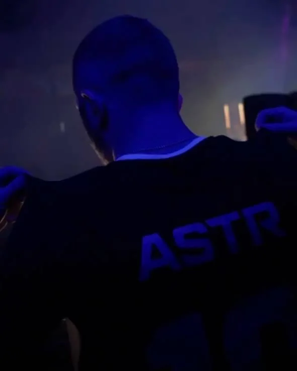 ASTR from behind wearing an ASTR jersey under blue stage light
