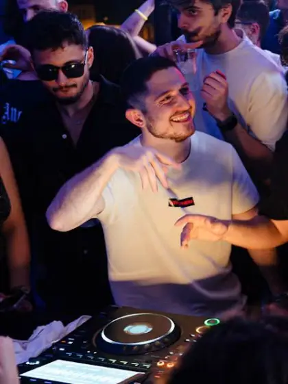 ASTR smiling behind the decks in a packed room
